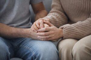 Zwei Menschen halten sich an den Händen als Symbol für Beziehungen und wichtige Entscheidungen im Leben.